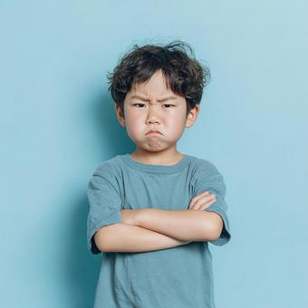 不満そうな表情で腕組みをする日本の小学生 不満そうな表情で腕組みをする日本の小学生の写真