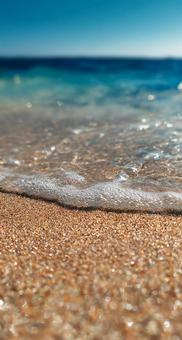 夏の日差しが輝く砂浜と波 夏の日差しが輝く砂浜と波の写真