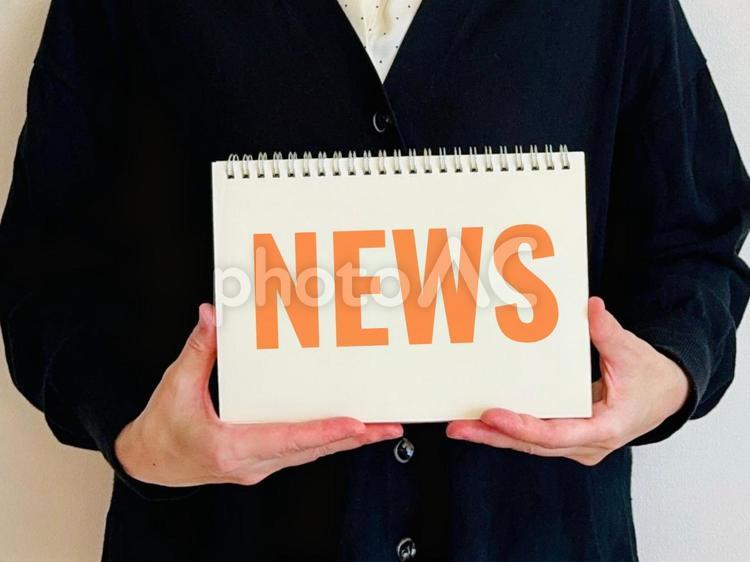 NEWSと書かれたノートを持つ女性 ニュース,お知らせ,案内の写真素材