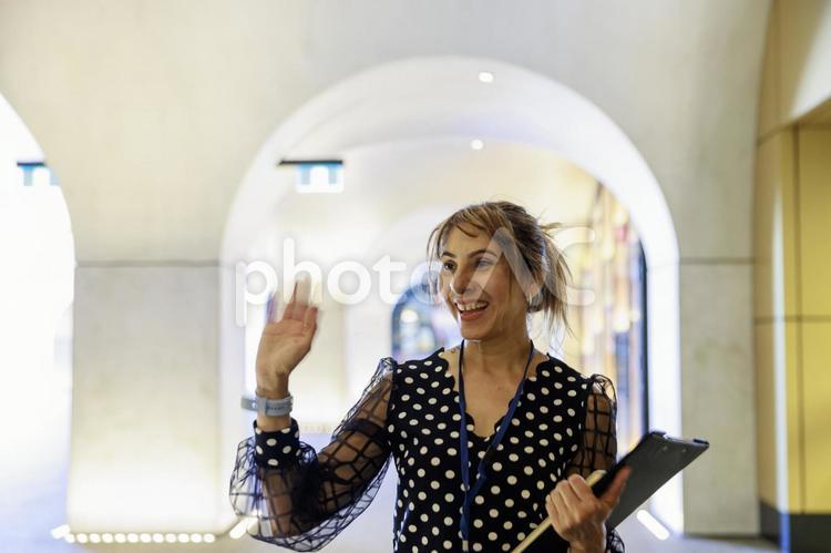 笑顔で手を振る外国人女性 笑顔,手を振る,挨拶の写真素材