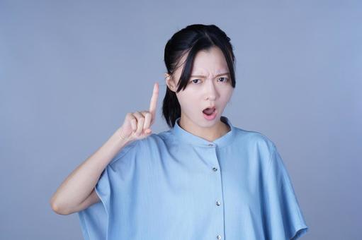 人差し指を立てた青い服の女性 女性,指差し,怒るの写真素材