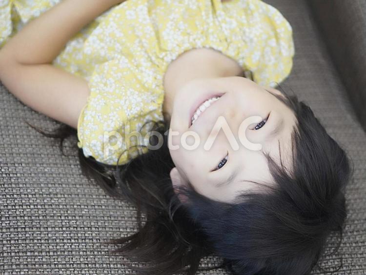 ソファーに寝転がる女の子 子供,女の子,寝転がるの写真素材