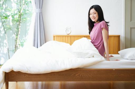 カメラ目線で笑うベッドの女性 女性,ベッド,笑うの写真素材