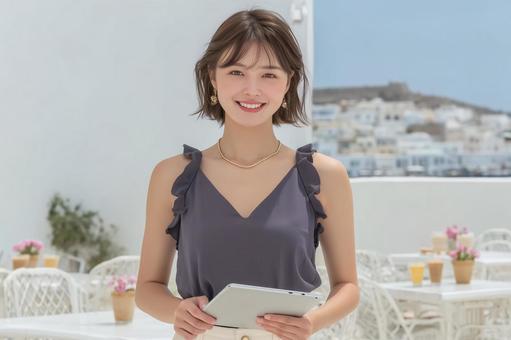 旅行先でタブレットを確認する女性 旅行先でタブレットを確認する女性の写真