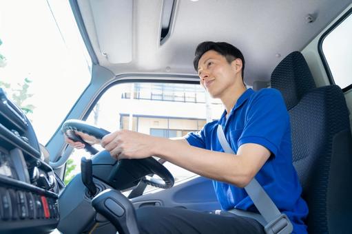 トラックを運転する男性ドライバー トラックを運転する男性ドライバー ドライバー,トラック,運転手の写真素材