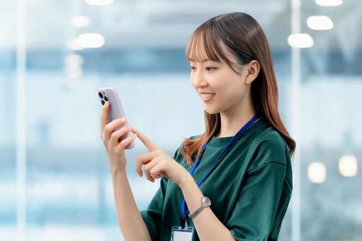 スマホを使う笑顔の女性・ビジネスウーマン 女性,スマホ,スマートフォンの写真素材