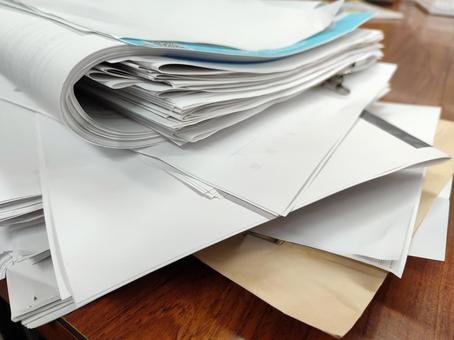 会社　紙書類　乱雑　木目テーブル ビジネス,オフィス,仕事の写真素材