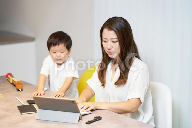 リモート中の母親の横で遊ぶ子供 女性,リモートワーク,子育ての写真素材