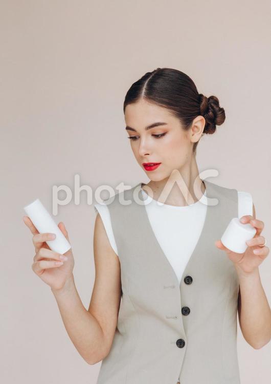 化粧品を持って見ている女性 女性,スタジオ撮影,持つの写真素材