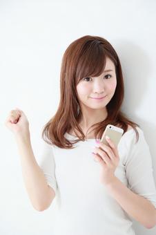 スマートフォンを使う女性 スマートフォンを使う女性 スマートフォン,カジュアル,検索の写真素材