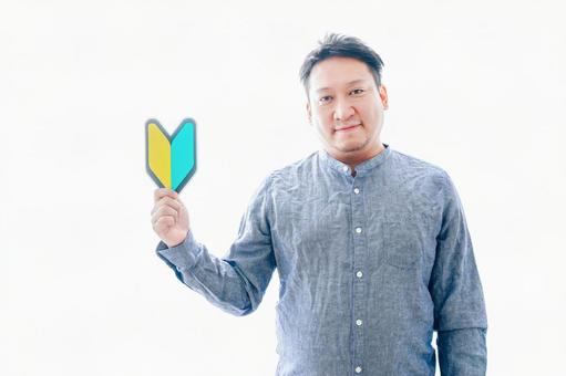 初心者マークを持つ中年男性 初心者マークを持つ中年男性 ビギナー,入門,やさしいの写真素材