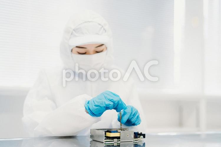 クリーンルームで精密機器を扱う女性 工場,製造業,精密機器の写真素材