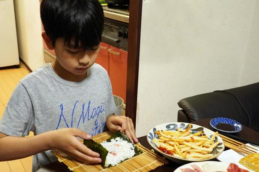 手巻き寿司の夕食のご飯を作る小学生の子供 手巻き寿司の夕食のご飯を作る小学生の子供の写真