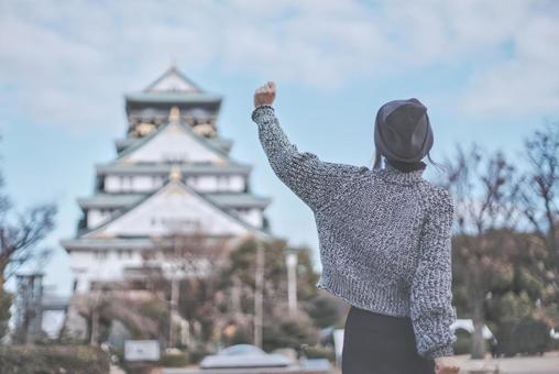 大阪城と喜ぶ女性旅行者の後ろ姿 大阪城と喜ぶ女性旅行者の後ろ姿の写真