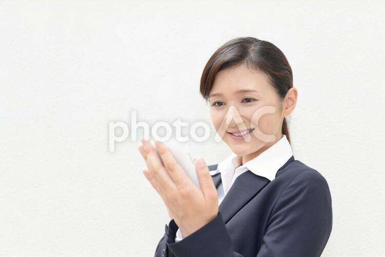 スマートフォンを持つ笑顔の女性 女性,ビジネスウーマン,女の写真素材