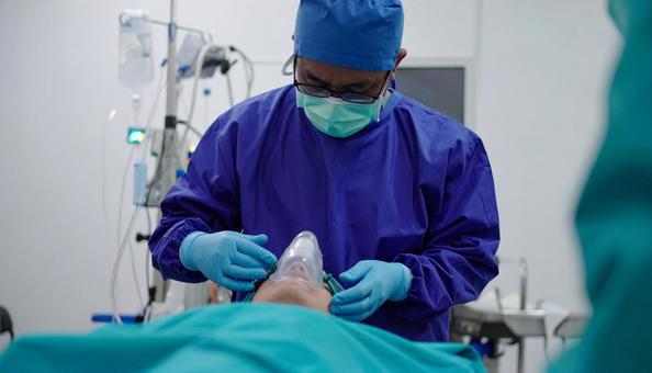 手術室で患者に全身麻酔を施す麻酔科医 手術室で患者に全身麻酔を施す麻酔科医の写真