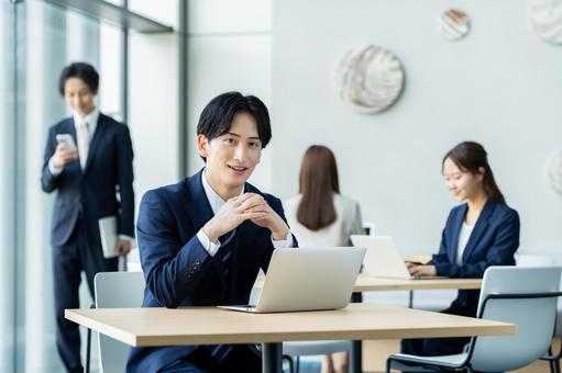 オフィスで働く若いビジネスマン オフィスで働く若いビジネスマンの写真