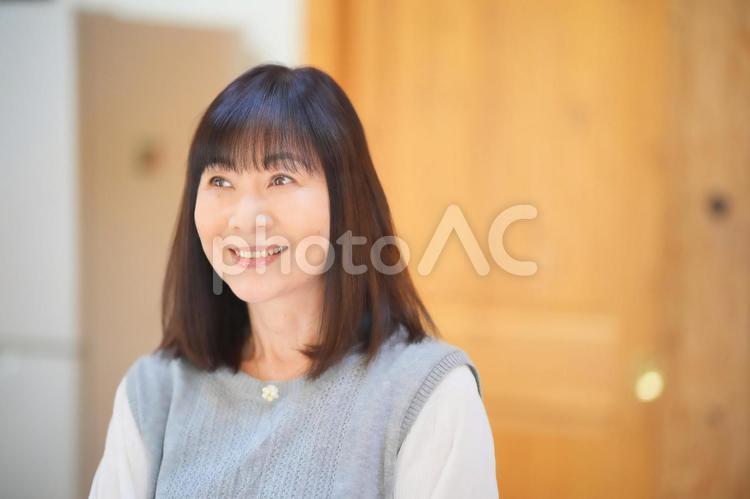 上目遣いの笑顔の女性 女性,日本人,50代の写真素材
