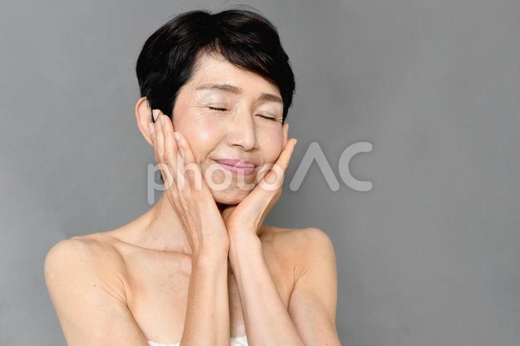 両手で頬を包む中高年のアジア人女性 中年,女性,フェイシャルケアの写真素材