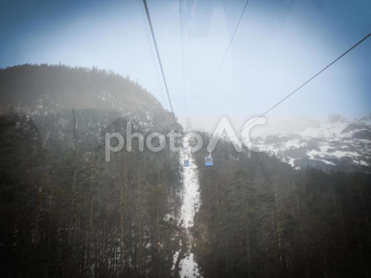 雪山を進む青いロープウェイと幻想的な風景 ロープウェイ,雪山,高山の写真素材