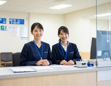 病院の受付コーナーで笑顔で迎える受付嬢 病院の受付コーナーで笑顔で迎える受付嬢の写真