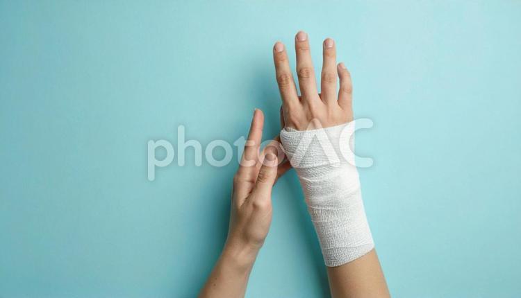 手首を怪我して包帯を巻いている女性の手 手,ケガ,手術の写真素材