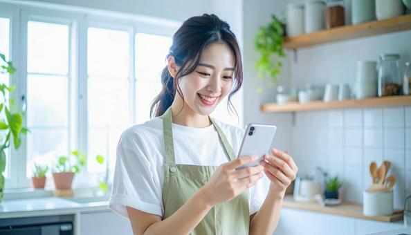 スマホでポイ活する笑顔の女性 スマホでポイ活する笑顔の女性の写真