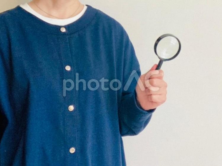 虫眼鏡を持つ女性（紺トップス） 虫眼鏡,女性,調査の写真素材