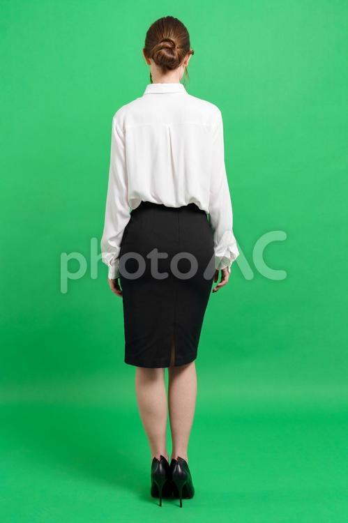 オフィスファッションの女性の後ろ姿（緑背景） 後ろ姿,立つ,ポーズの写真素材