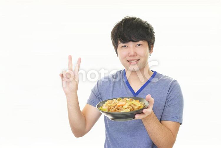 料理を持つ笑顔の男性 男性,男,焼きそばの写真素材