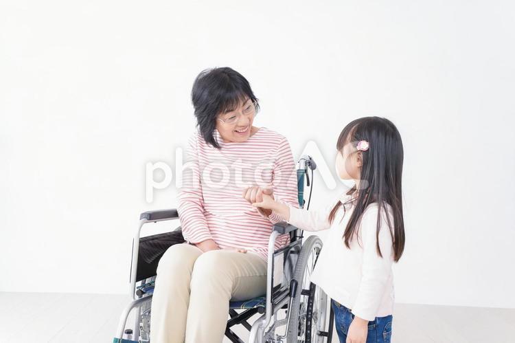 車椅子に乗るおばあちゃんと女の子 身体障害,医療,保育園児の写真素材