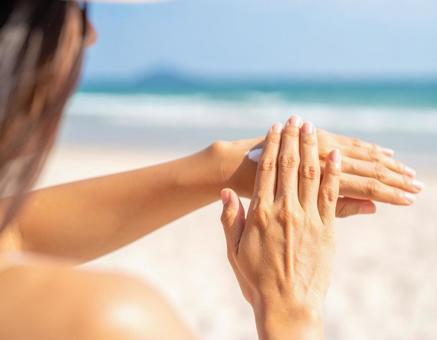 日焼け止めを塗る女性 日焼け止めを塗る女性の写真