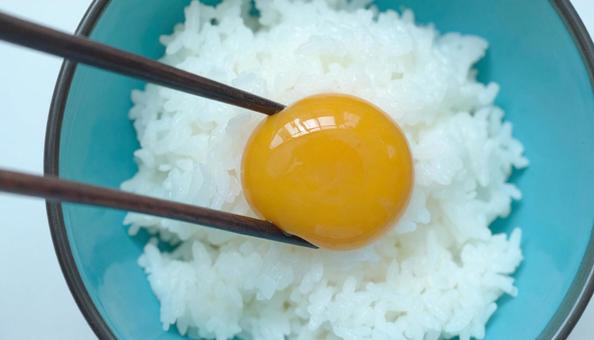 卵かけご飯 生卵の黄身を箸でつぶす 卵かけご飯 生卵の黄身を箸でつぶすの写真