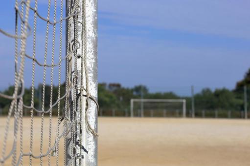 サッカーのゴールポストから望む1 ゴールポスト,青空,土のグラウンドの写真素材