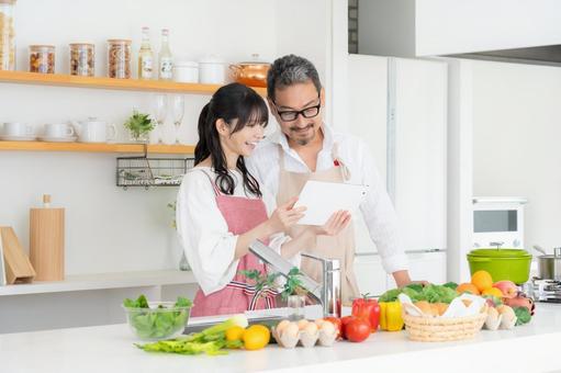 キッチンで料理を作るミドルの夫婦 キッチンで料理を作るミドルの夫婦 料理,夫婦,家族の写真素材