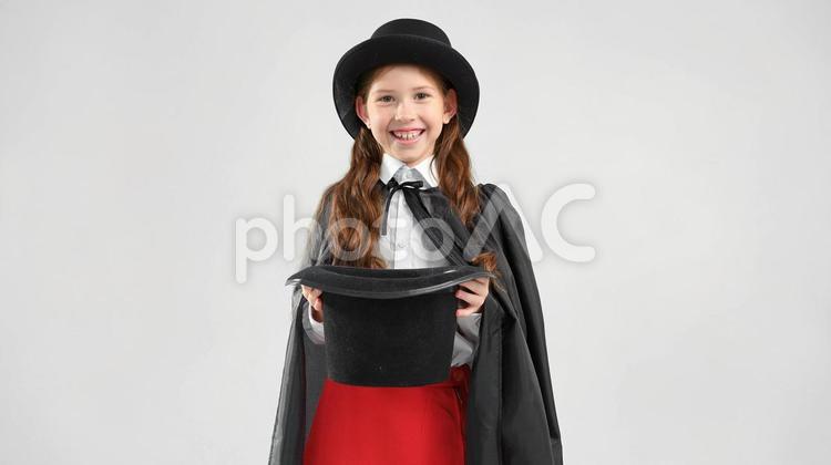 笑顔で黒い帽子を持つ女の子 女の子,マジック,帽子の写真素材
