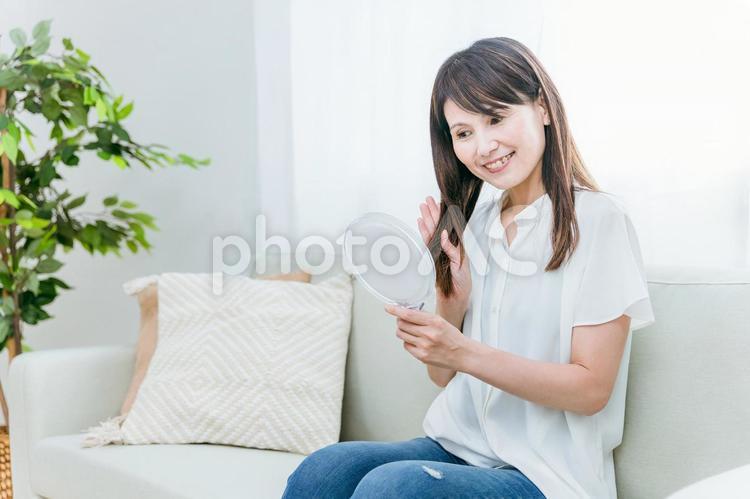 髪の毛が綺麗なミドル世代の女性 髪の毛,ヘアケア,ソファーの写真素材