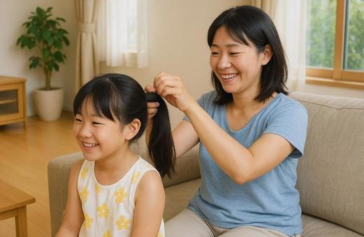 髪の毛を結んでもらっている女の子 髪の毛を結んでもらっている女の子の写真