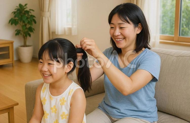 髪の毛を結んでもらっている女の子 親子,女の子,女性の写真素材