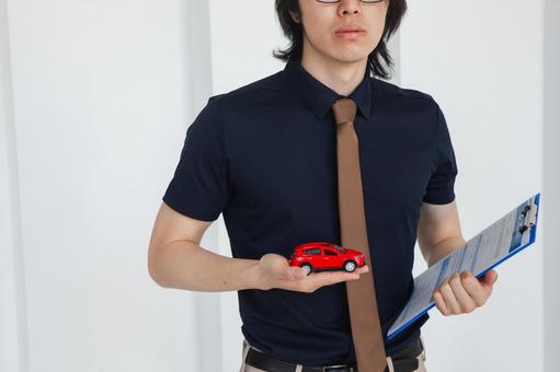 手のひらに赤い車を持つ男性 保険業,事務職,接客業の写真素材