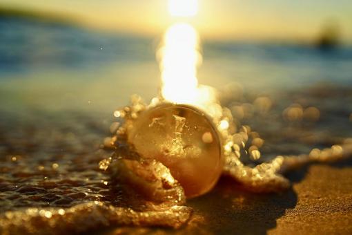 水晶玉越しの波打ち際と与那覇前浜の夕焼け 水晶玉越しの波打ち際と与那覇前浜の夕焼け 水晶玉,水晶玉写真,クリスタルボールの写真素材