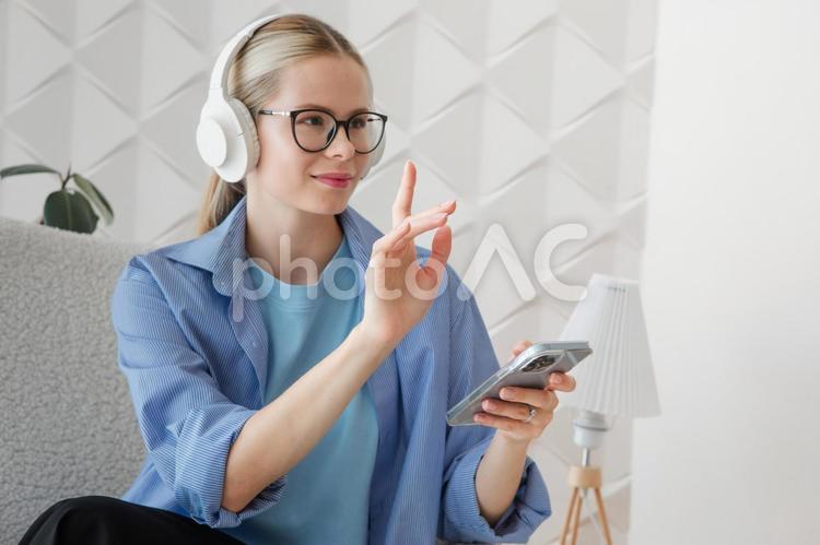 スマホを持ちポーズする女性 女性,笑顔,嬉しいの写真素材