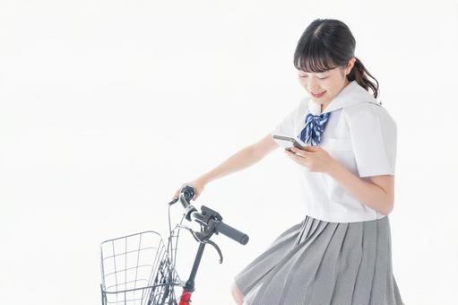 自転車でスマホを使う若い学生 自転車でスマホを使う若い学生 制服,女性,通話の写真素材