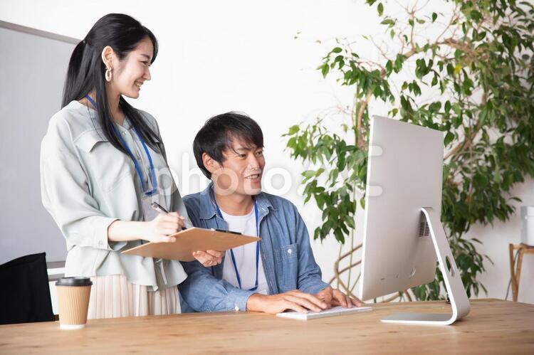 オフィスでミーティングする男女の会社員 クリエイター,エンジニア,デザイナーの写真素材