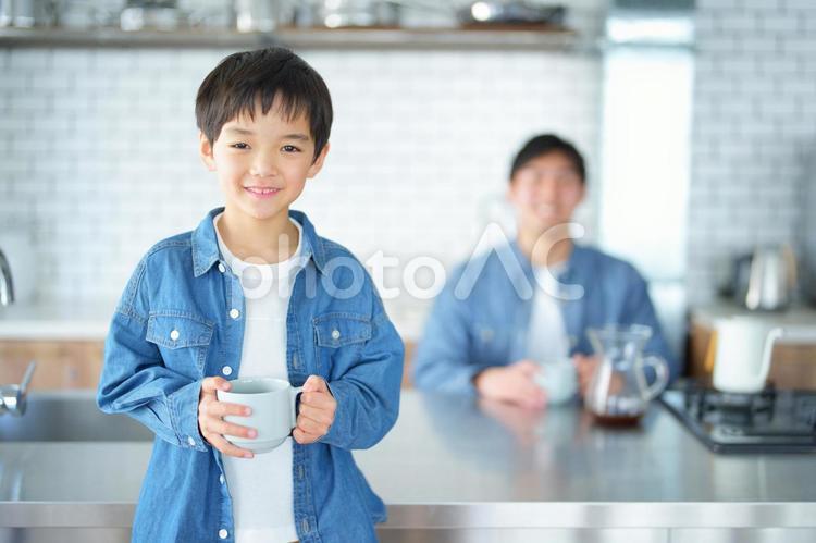 カップを持っている男の子と後ろに男性 親子,男の子,コーヒーの写真素材