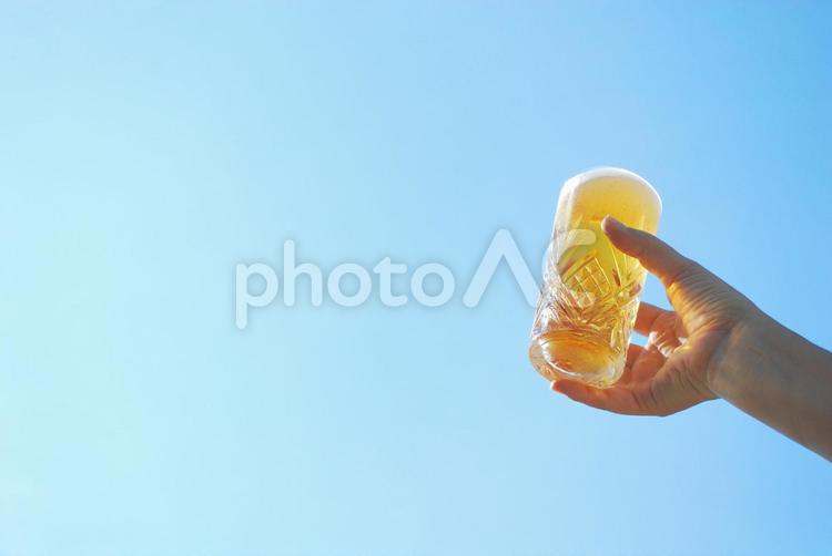 青空とビールグラスと女性の手　右寄せ 青空,ビール,夏の写真素材
