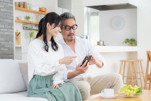 リビングでスマホを見るミドルの夫婦 リビングでスマホを見るミドルの夫婦 夫婦,家族,ミドルの写真素材
