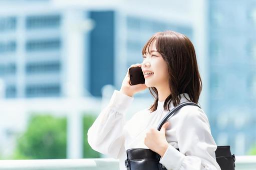 スマホで話す笑顔の女性・ビジネスウーマン 女性,スマホ,夏の写真素材