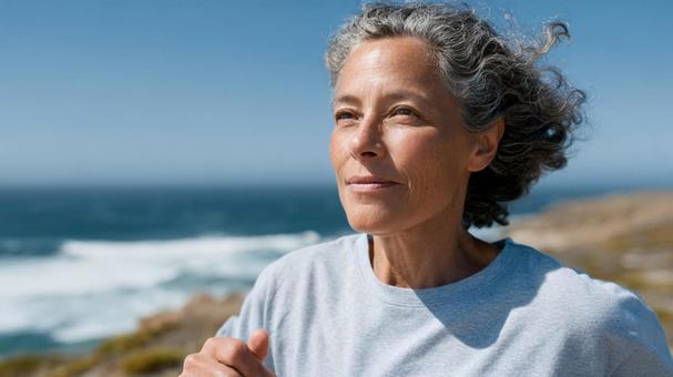 海沿いの場所でランニングするシニア女性 海沿いの場所でランニングするシニア女性の写真