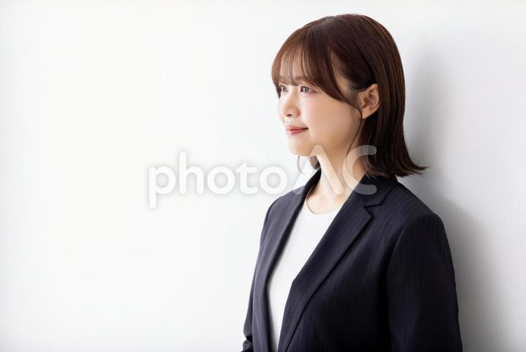 白壁に寄りかかるビジネスウーマン 女性,ビジネスウーマン,日本人の写真素材